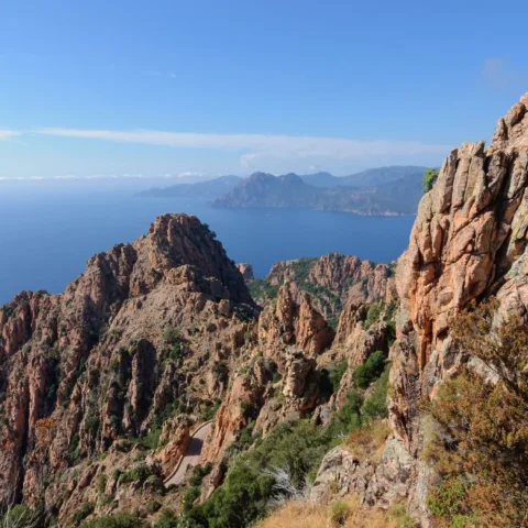 Les roches de granit rouge des Calanche de Piana dominant le golfe de Porto, route en contrebas.