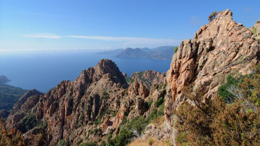 Les roches de granit rouge des Calanche de Piana dominant le golfe de Porto, route en contrebas.